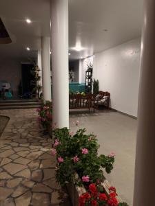 eine Lobby mit Blumen, einer Säule und einem Tisch in der Unterkunft Kelly Mercedes in Chachapoyas