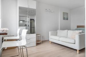 ein weißes Wohnzimmer mit einer weißen Couch und einer Küche in der Unterkunft Bondi Beach Studio with an ocean view in Sydney + 9 Fotos