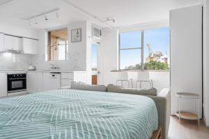 ein weißes Schlafzimmer mit Bett und Küche in der Unterkunft Bondi Beach Studio with an ocean view in Sydney