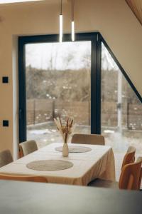 uma mesa de jantar com um vaso de flores sobre ela em Lofty House Mountain em Urych