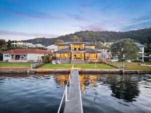 a large house on the water with a dock at Waters Edge by Coast Hosting in Koolewong