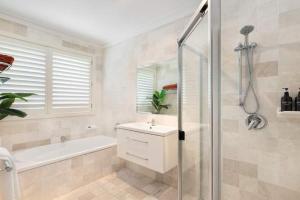 a bathroom with a tub and a sink and a shower at Waters Edge by Coast Hosting in Koolewong +16 photos