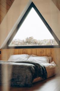 a bed in a room with a large window at Lofty House Mountain Tustan in Urych