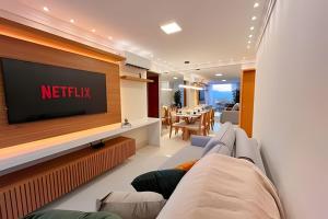 ヴィラ・ヴェーリャにあるPRAIA Mar e Sofisticação - Novo!の壁にテレビが掛かっているリビングルーム