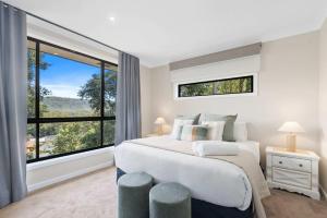 a bedroom with a bed and a large window at Ruby Lodge by Coast Hosting in Green Point