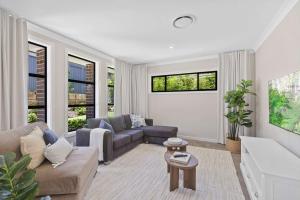 a living room with a couch and a table at Ruby Lodge by Coast Hosting in Green Point