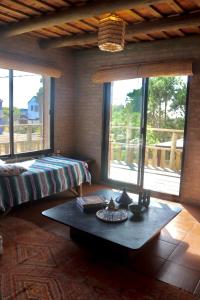 een kamer met een bed, een tafel en ramen bij Castillito de la viuda casa para 5o 6 personas in Punta Del Diablo