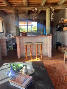 een keuken met een aanrecht en 2 krukken bij Castillito de la viuda casa para 5o 6 personas in Punta Del Diablo +16 foto's