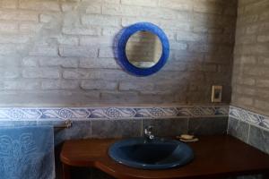 een badkamer met een blauwe wastafel en een spiegel bij Castillito de la viuda casa para 5o 6 personas in Punta Del Diablo