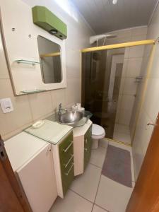 a small bathroom with a sink and a shower at Pousada da Marli in Torres +31 photos