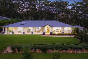 a large white house with a large yard at Tarragal by Coast Hosting in Terrigal