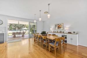 a kitchen and dining room with a table and chairs at Tarragal by Coast Hosting in Terrigal