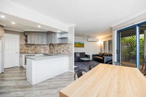 cocina y sala de estar con mesa, cocina y comedor en Grange Resort Hervey Bay, en Hervey Bay