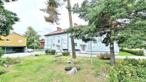 a large white building with trees in the yard at Coastal Wooden Apartment Rauma in Rauma