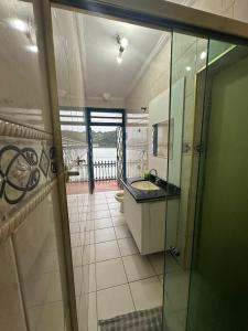 bagno con lavandino e porta a vetri di Pousada Recanto da Prainha a São Vicente