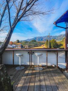 a porch with two stools and a view of the mountains at Stay at matcha fields in Wazuka +32 photos