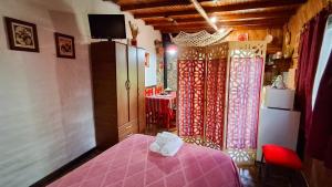 1 dormitorio con cama rosa y mesa en Cabaña 'Te para Tres' Merlo San Luis, en Merlo 4 fotos más