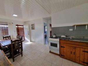 a kitchen and dining room with a table and a stove at Cabaña zona vivero in Miramar