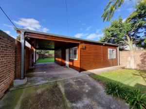 a house with a garage with a brick wall at Cabaña zona vivero in Miramar