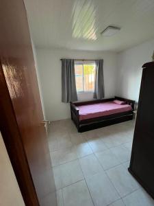 een slaapkamer met een bed en een raam bij Cabaña zona vivero in Miramar