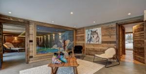 ein Wohnzimmer mit Holzwänden sowie einem Tisch und Stühlen in der Unterkunft Chalet Petit Alaska Val d Isere in Val dʼIsère