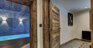 eine Holztür in einem Zimmer mit einer Wand in der Unterkunft Chalet Petit Alaska Val d Isere in Val dʼIsère + 49 Fotos