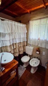 un baño con inodoro y lavabo en Cabaña 'Te para Tres' Merlo San Luis, en Merlo