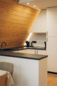 uma cozinha com armários brancos e um tecto de madeira em Lofty House Mountain em Urych