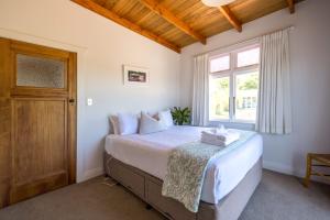 Ένα ή περισσότερα κρεβάτια σε δωμάτιο στο Pat's Bach - Elevated Bay Views Over Little Oneroa +11 φωτογραφίες