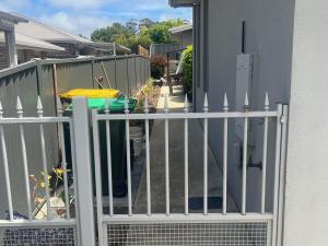 a white fence in front of a house at Blue Iris in Penguin