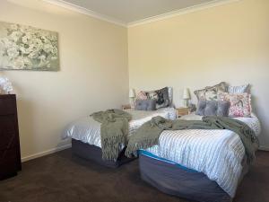 a bedroom with two beds with blankets on them at Blue Iris in Penguin