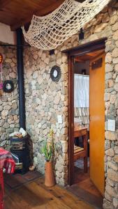 Habitación con pared de piedra y puerta de madera. en Cabaña 'Te para Tres' Merlo San Luis, en Merlo