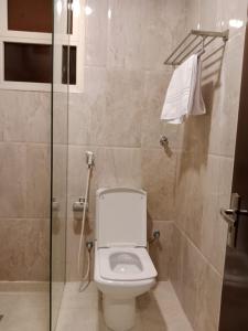 ein Badezimmer mit Toilette und Glasdusche in der Unterkunft فندق اوتاد البدر الششه in Al Khansāk