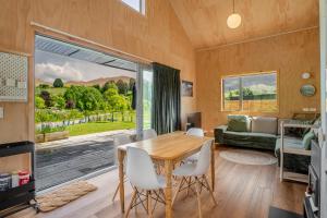 a living room with a wooden table and a large window at Mountain View Barn with Spa in Queenstown