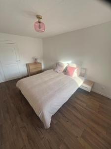 una camera da letto con un letto grande con lenzuola e cuscini bianchi di Spacieux appartement cozy a Saales Altre 7 foto