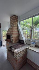 un forno in mattoni in una stanza con finestra di Alaercio goulart a Palhoça