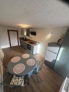 una cucina e una sala da pranzo con tavolo e frigorifero di Spacieux appartement cozy a Saales