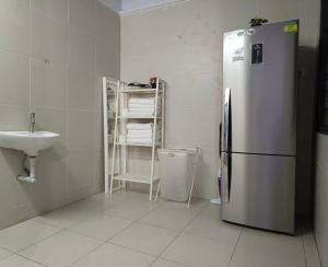 een keuken met een roestvrijstalen koelkast en een spoelbak bij Melaka Kota Home in Melaka