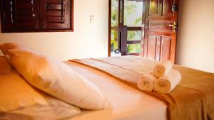 un letto con due asciugamani sopra e una porta di Casa Camboa - Barrinha - Praia do Preá ad Acaraú