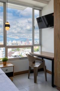 un dormitorio con escritorio y una ventana grande en Edificio Plaza U Wellness, en Pereira