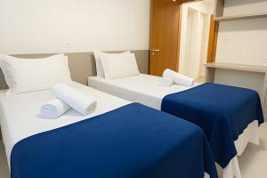 2 letti con lenzuola blu in una stanza di Itaparica Beira-Mar [Confortável e Pé na areia] a Vila Velha