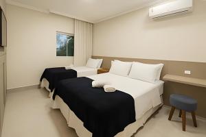 una stanza d'albergo con due letti e una sedia di Itaparica Beira-Mar [Confortável e Pé na areia] a Vila Velha