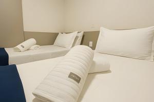 una camera d'albergo con due letti e un divano di Itaparica Beira-Mar [Confortável e Pé na areia] a Vila Velha Altre 20 foto