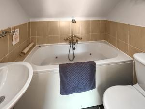 een badkamer met een bad, een toilet en een blauwe handdoek bij Lauras Loft - Uk49740 in Fulletby