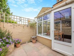 een intern uitzicht op een serre met glazen schuifdeuren bij Cygnet Cottage in Warkworth +8 foto's
