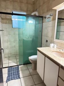 un bagno con doccia, WC e lavandino di Pousada Blue Beach House a Peruíbe