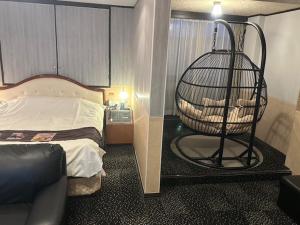 a room with a bed and a chair in a room at Hotel LAGNA in Moriyama