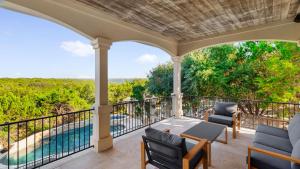 eine Veranda mit Stühlen und Poolblick in der Unterkunft Two House Estate W Stunning Pool & Views in The Hills