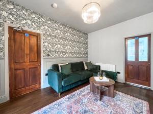 ein Wohnzimmer mit einer grünen Couch und einem Tisch in der Unterkunft Botany Bay House in Whitby