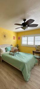 Un dormitorio con una cama con ventilador de techo. en Yellow Cactus Oasis, en White Water